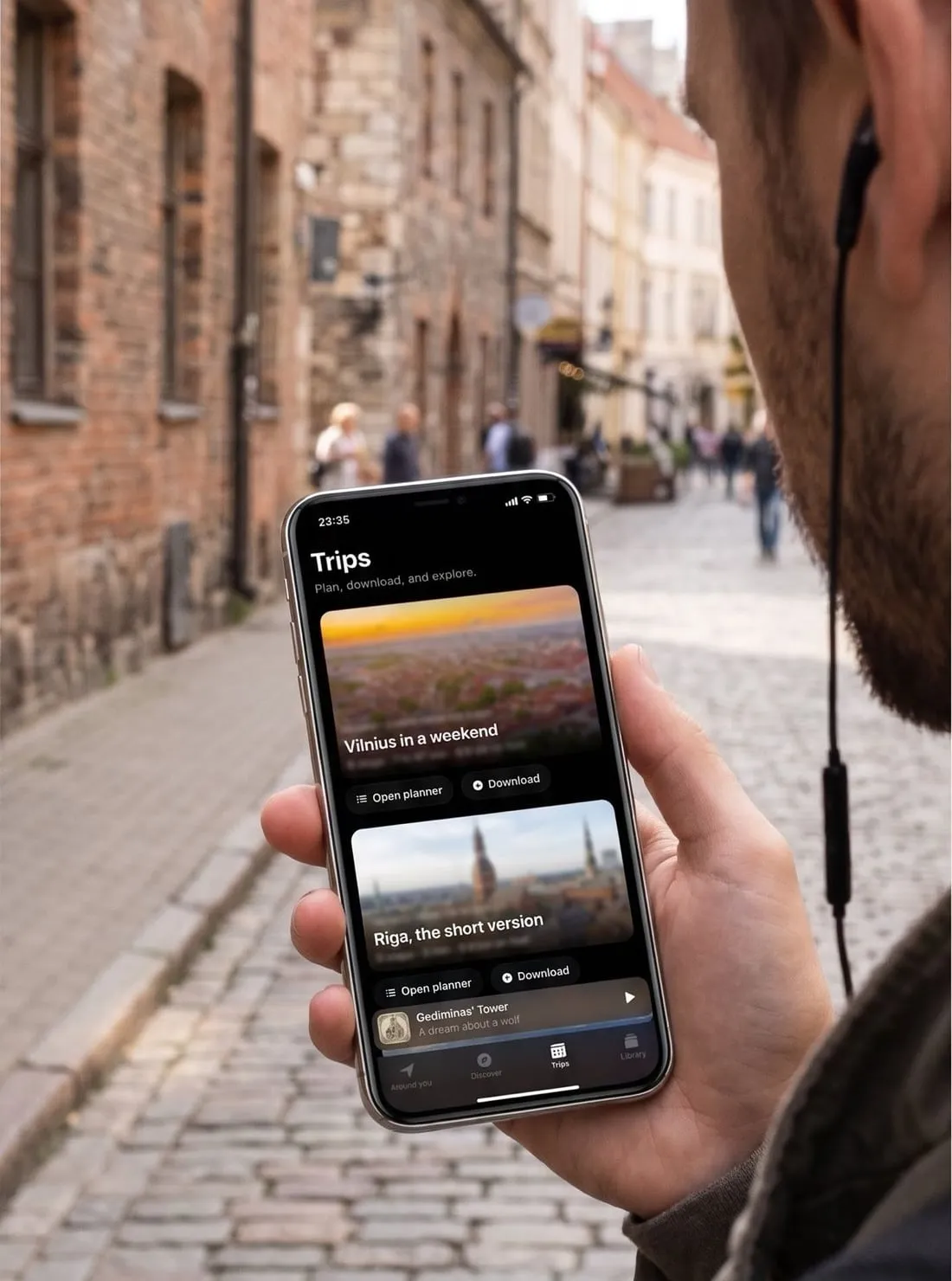 Keliautojas senamiestyje klausosi GuideBuddy gido telefone